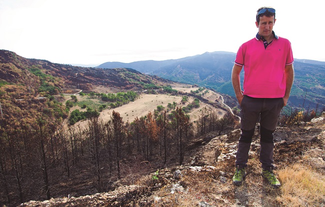 Ángel Eraso Azkona muestra al fondo el área donde pastan sus animales y que no resultó afectada por el fuego.
